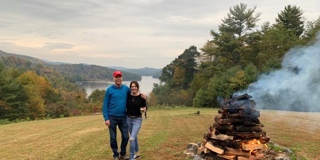 Grandparents standing by bonfire in North Carolina hills